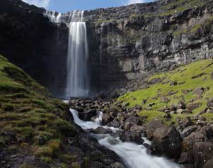 Wasserfall mit Lavagestein auf den Färöer Inseln