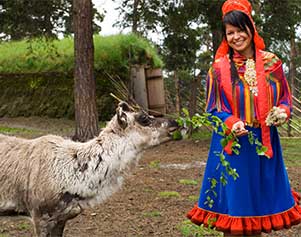 Samische Frau in traditioneller Tracht mit Rentier - Finnmark Johan Wildhagen VisitNorway.com