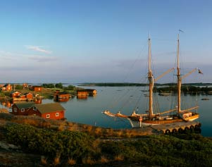 Segelboot und Häuser an der Küste der Ålandinseln