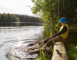 Kind, das in einem See in Finnland planscht