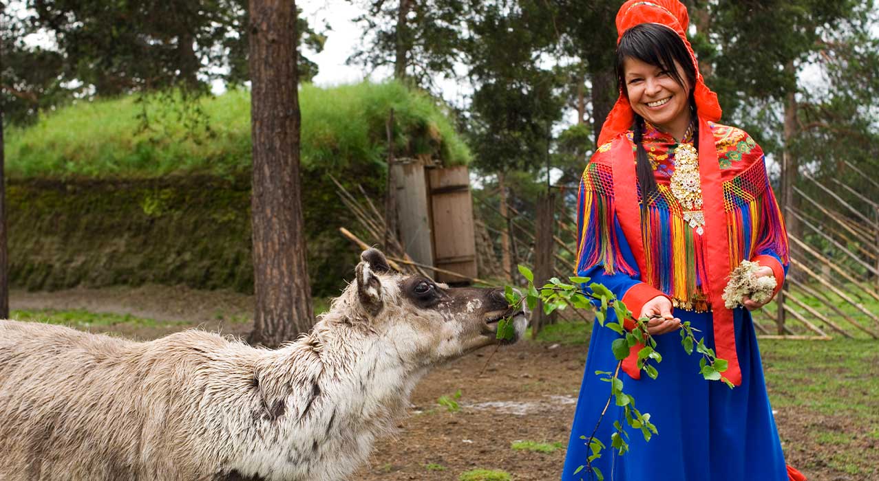 Samische Frau in traditioneller Tracht mit Rentier - Finnmark Johan Wildhagen VisitNorway.com