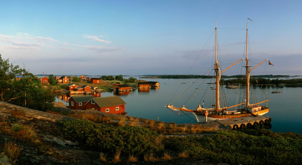 Häuser und Segelboot an der Küste einer Åland Insel